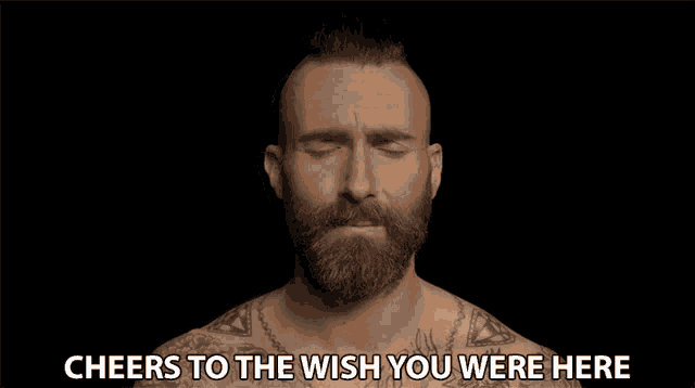 a man with a beard and tattoos is singing cheers to the wish you were here