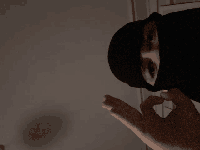 a person wearing a black mask with their face covered