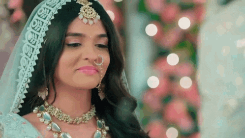 a close up of a woman wearing a wedding dress and jewelry .