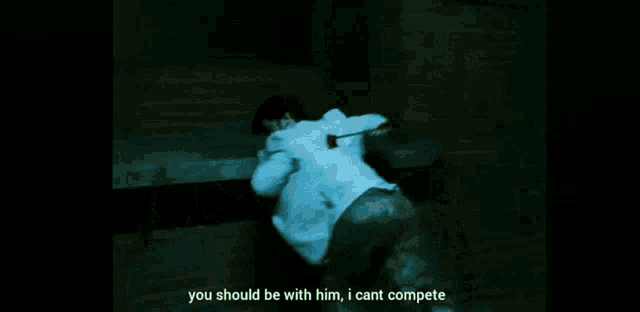 a man in a white shirt is laying on the ground with a sword in his back .