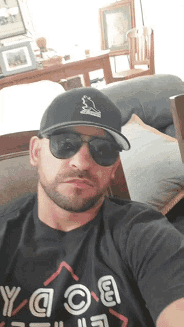 a man wearing a hat and sunglasses is wearing a shirt that says yaoa
