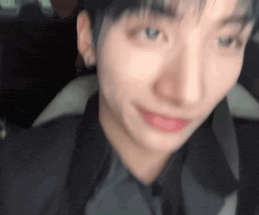 a close up of a person 's face in a car with a blurred background .