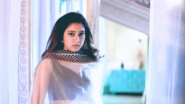 a woman in a white dress is standing in a hallway .