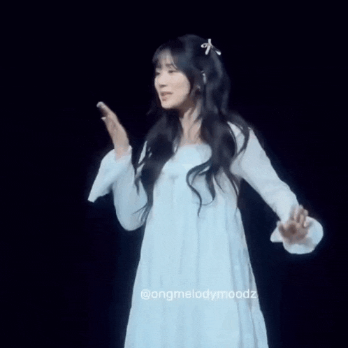 a woman in a white dress is standing on a stage .