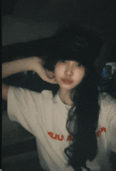 a woman wearing a white t-shirt with the letter a on it takes a selfie