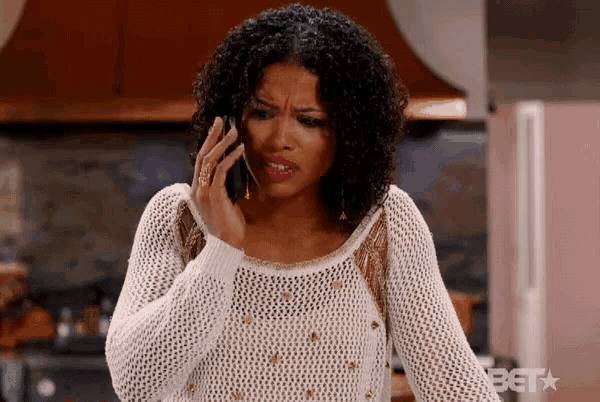 a woman in a white sweater is talking on her cell phone