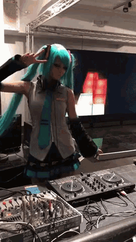 a woman in a hatsune miku costume giving a peace sign in front of a dj mixer
