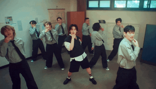 a group of men in ties are dancing in a room with a map on the wall that says ' seoul ' on it