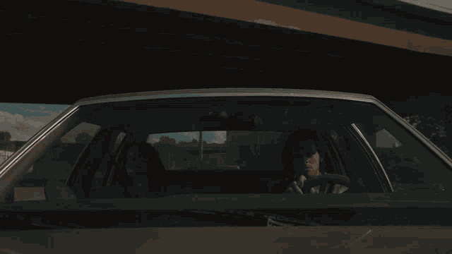 a man is driving a car with a woman in the back seat