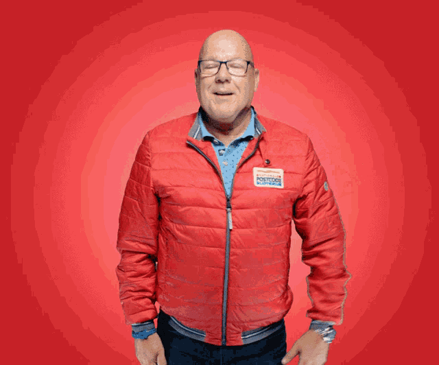 a man wearing a red jacket with a sticker on it that says ' amsterdam postcode ' on it