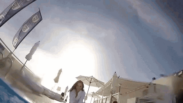 a woman is swimming in a pool with a banner that says ' gulf ' on it