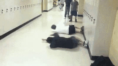a group of people laying on the floor in a hallway .