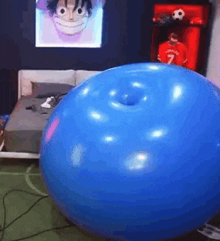 a large blue balloon with a hole in the middle is sitting in a bedroom .