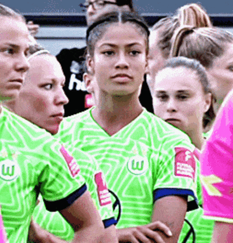 a group of women wearing green and pink jerseys with the letter w on the front