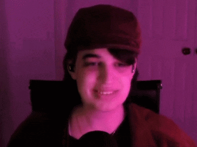 a woman wearing a hat and ear buds is giving two thumbs up .