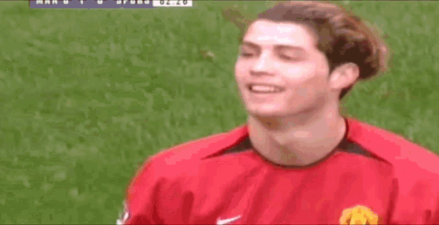 a close up of a soccer player wearing a red nike jersey on a field .