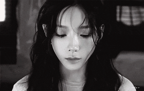 a black and white photo of a woman 's face with the letters eee visible