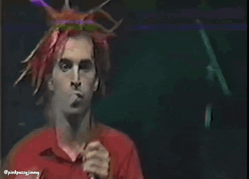a man in a red shirt is singing into a microphone with the hashtag pinkpussyjimmy
