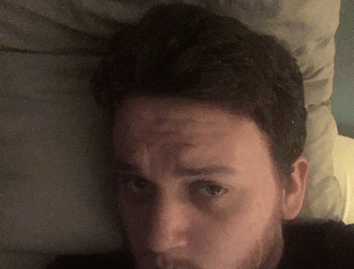 a man with a beard is laying on a bed