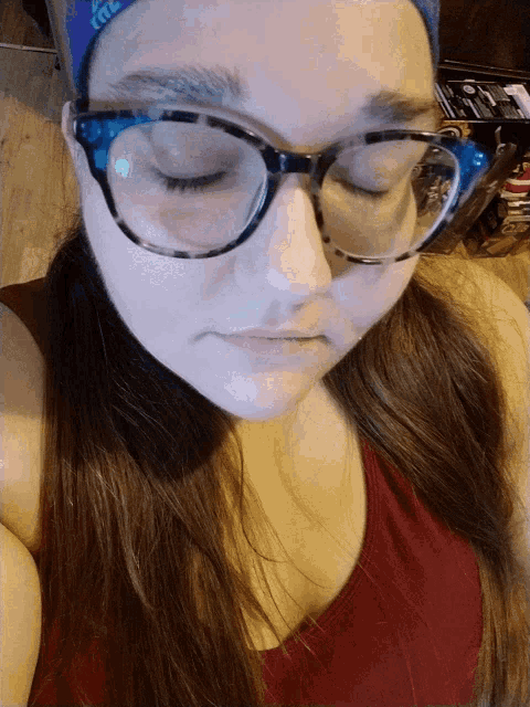 a woman wearing glasses and a bandana with the word lite on it looks down