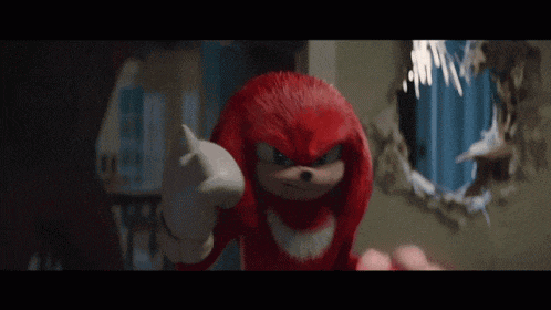 knuckles the echidna from the movie sonic the hedgehog is standing in front of a hole in a wall .