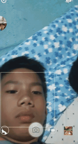 a young boy is taking a picture with a camera