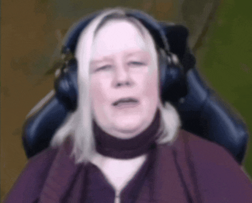 a woman wearing headphones sitting in a chair with her eyes closed