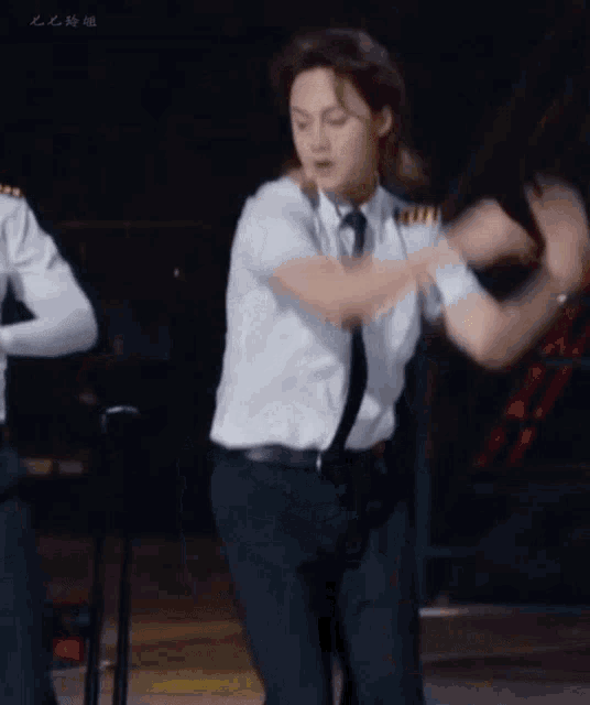 a man in a white shirt and tie is dancing on a stage