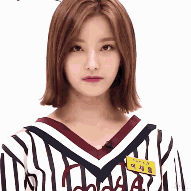 a woman with short hair is wearing a striped shirt and has a name tag on her chest .