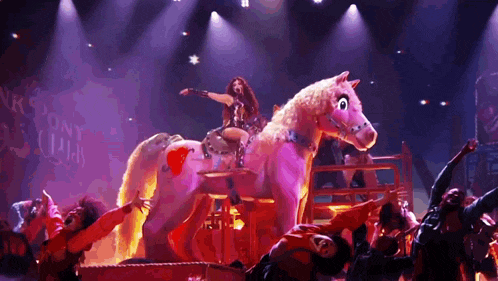 a woman is riding on the back of a pink horse