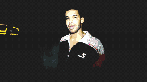 a man in a red white and black sweater is standing in the dark