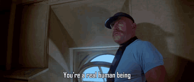 a man in a blue shirt and hat says you 're a real human being