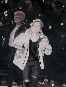 a couple of men are dancing on a stage in front of a crowd of people