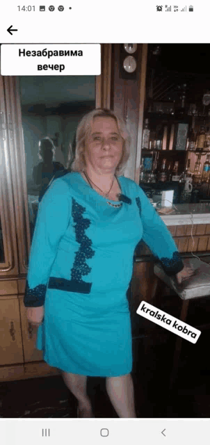 a woman in a blue dress stands in front of a bar with a sticker that says kralska kobra