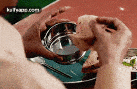 a person is taking a bite out of a sandwich .