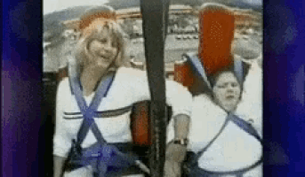 a couple of people sitting on a roller coaster with a blue background