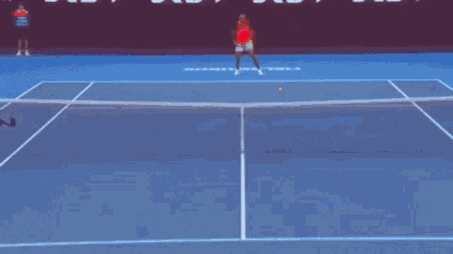 a man in a red shirt is playing tennis on a blue court with the word shanghai on it