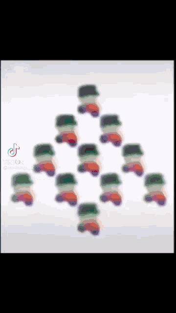 a group of gummy bears are lined up in a triangle on a white surface .