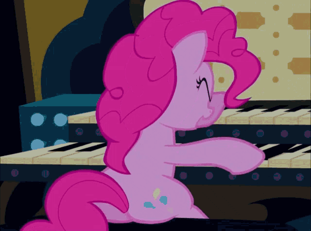 a pink pony is playing a piano in a dark room