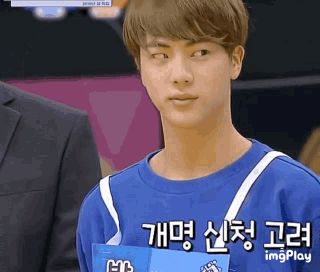 a young man wearing a blue shirt with a name tag that says ' imgplay ' on it