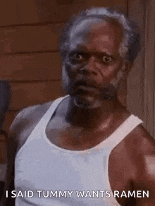 a man with a beard and mustache is wearing a white tank top and saying i said tummy wants ramen .