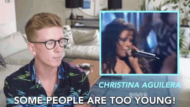 a man wearing glasses looks at a picture of christina aguilera from 2003