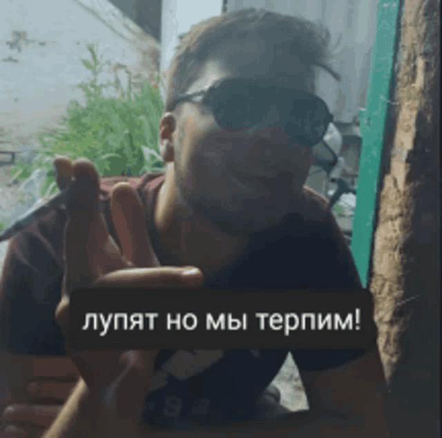 a man wearing sunglasses and a shirt that says ' adidas '