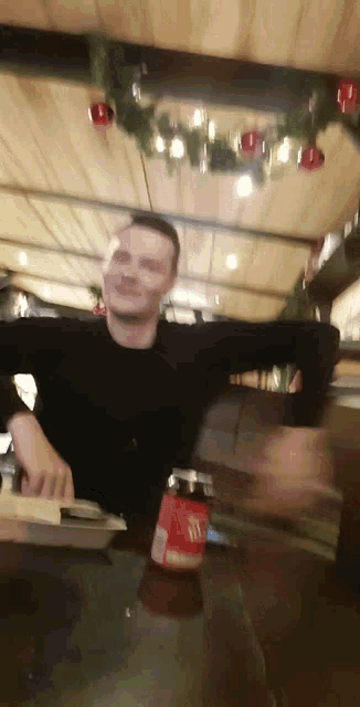 a man sitting at a table with a coca cola bottle