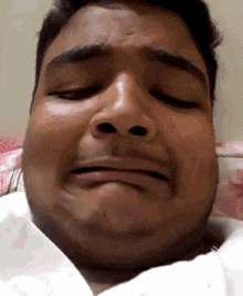 a man with his eyes closed is making a funny face