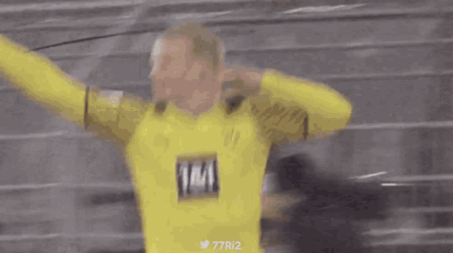 a man in a yellow shirt with the number 77r12 on the bottom