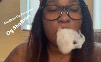 a woman wearing glasses is blowing a bubble with the words og sha brim on the bottom