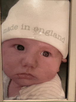 a baby wearing a hat that says made in england on it