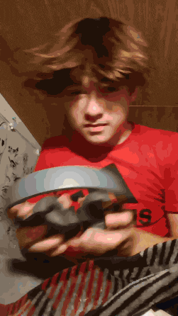 a boy wearing a red shirt with the number 19 on it holds something in his hands