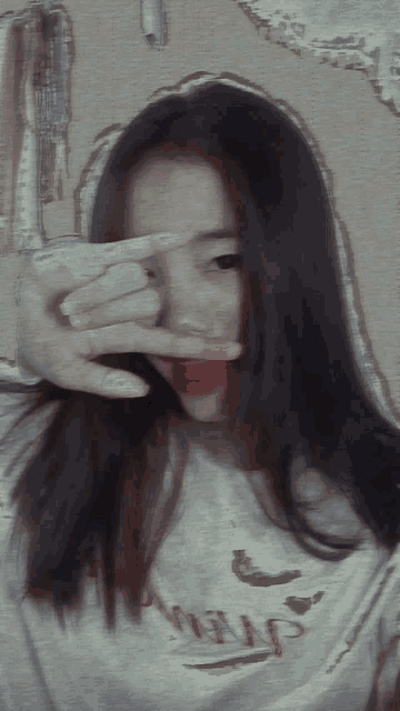 a girl taking a picture of herself with her fingers in front of her eyes